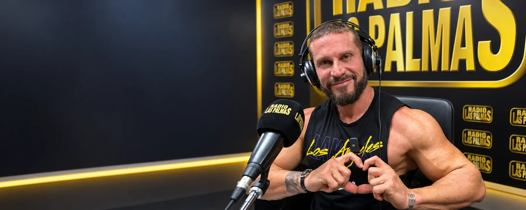 Fran Susín wearing headphones at Radio Las Palmas, making a heart shape with his hands